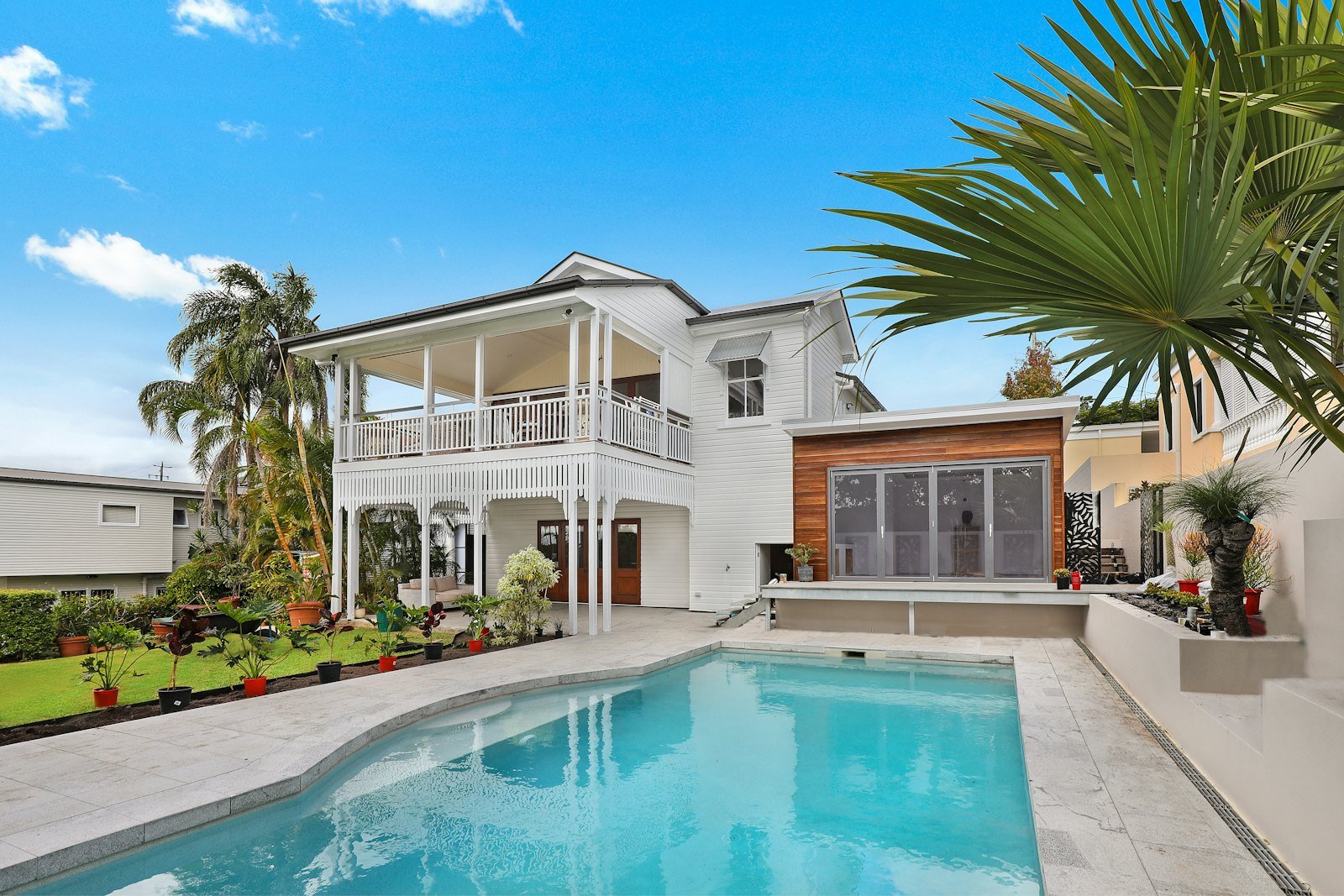 Two-storey family home with a lawn and large windows